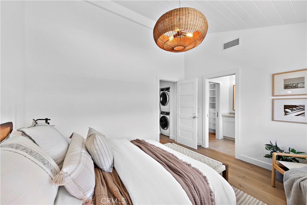 25 Blue Lagoon Laguna Beach, CA 92651 - Photo 34 of 53 a bedroom with a bed and a chandelier