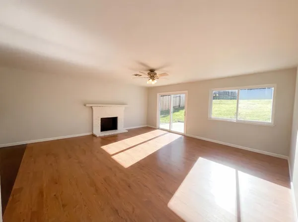 a view of an empty room with a window and a fireplace