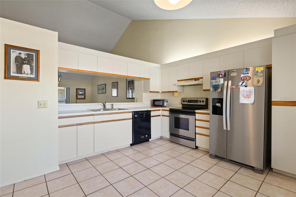1801 East Lake Road South, Unit 4E Palm Harbor, FL 34685 - Photo 6 of 26 a kitchen with granite countertop cabinets and steel stainless steel appliances