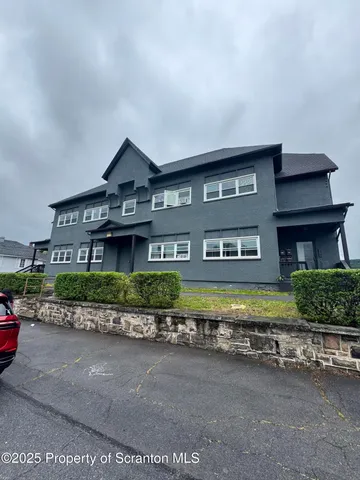 a front view of a house with a yard and outdoor seating