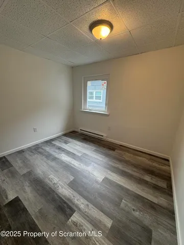 a view of a room with wooden floor and fan