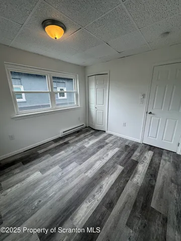 a view of a room with wooden floor and window