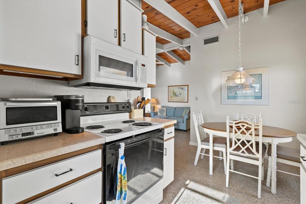 6006 Midnight Pass Road, Unit 11 Sarasota, FL 34242 - Photo 11 of 45 a kitchen with stainless steel appliances granite countertop a stove and a microwave