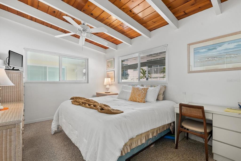 6006 Midnight Pass Road, Unit 11 Sarasota, FL 34242 - Photo 13 of 45 a bedroom with a bed a table and chair