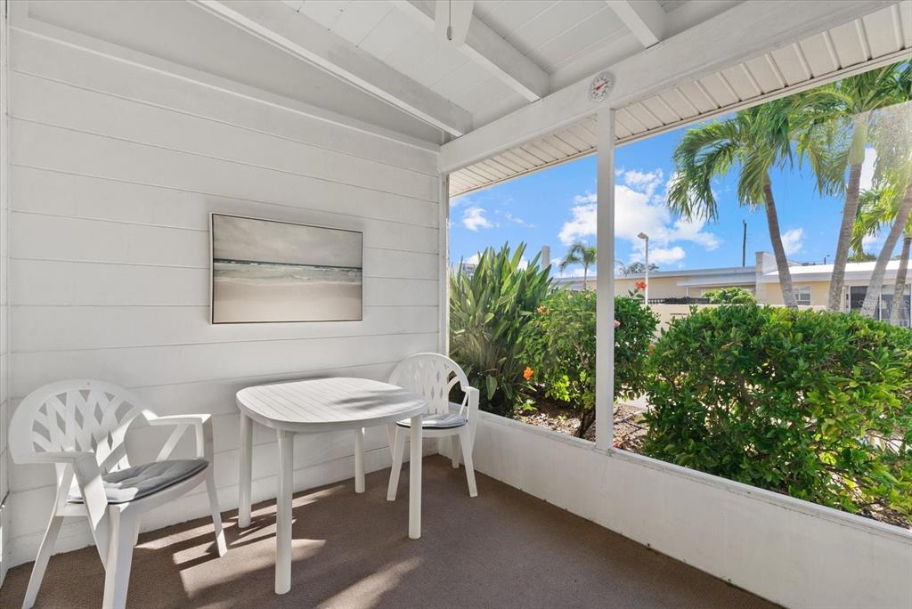 6006 Midnight Pass Road, Unit 11 Sarasota, FL 34242 - Photo 18 of 45 a view of a chairs and table in a patio