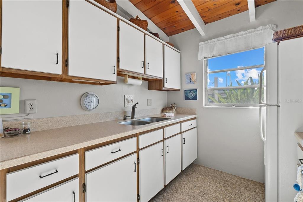 6006 Midnight Pass Road, Unit 11 Sarasota, FL 34242 - Photo 10 of 45 a kitchen with a sink cabinets and a window
