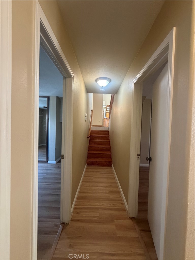 19609 Seneca Road Apple Valley, CA 92307 - Photo 25 of 37 a view of a hallway with wooden floor and stairs