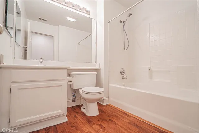 a bathroom with a bathtub shower sink vanity and toilet