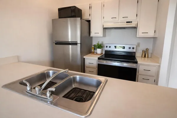 a kitchen with white cabinets and stainless steel appliances