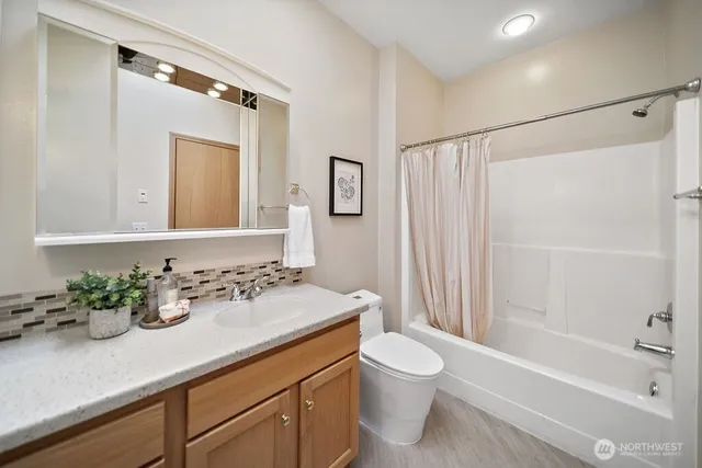 a living room with furniture large window and dresser