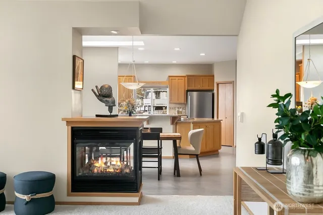 a living room with furniture a fireplace and a floor to ceiling window