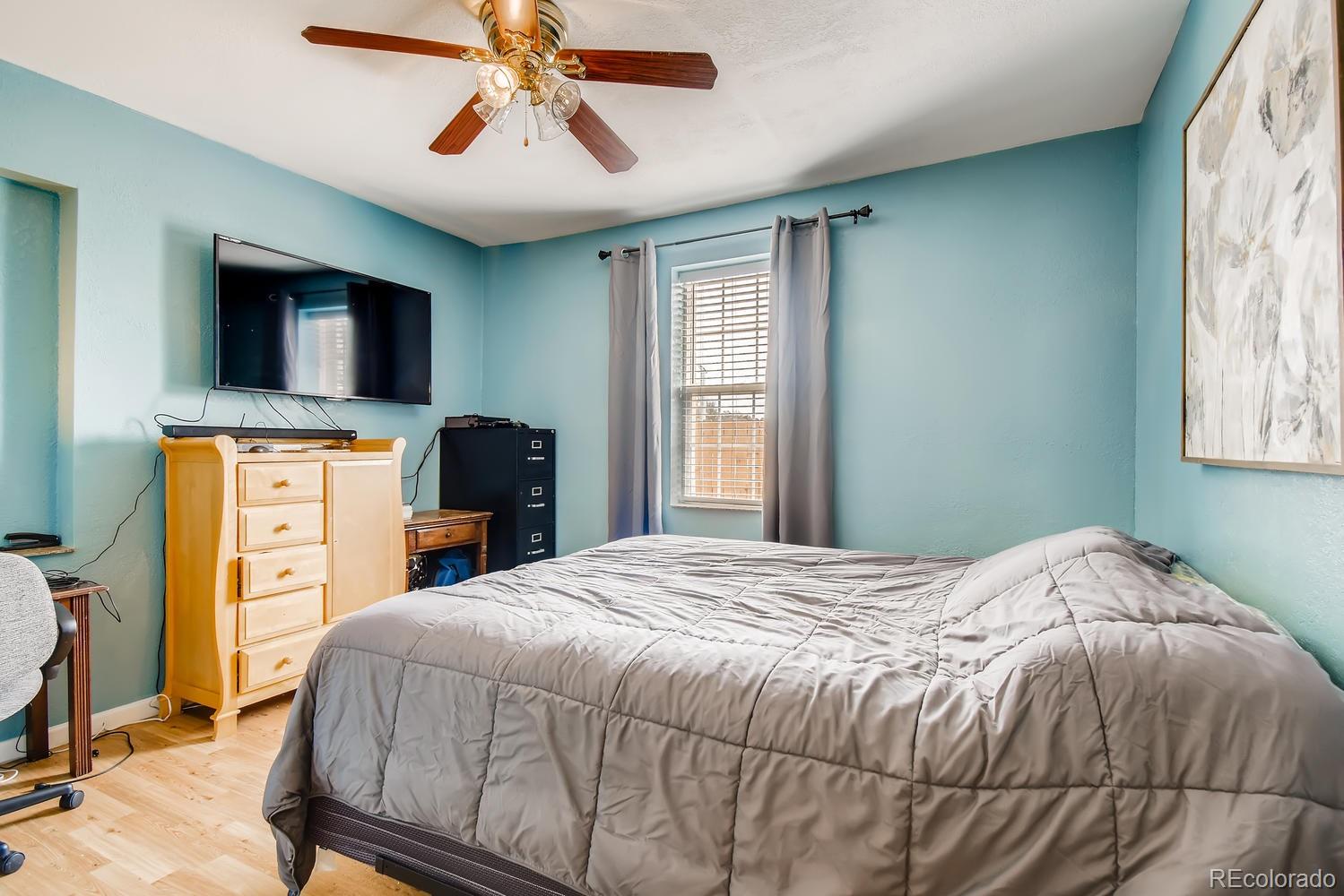 816 3rd Street Fort Lupton, CO 80621 - Photo 21 of 31 a bedroom with a bed and a chandelier