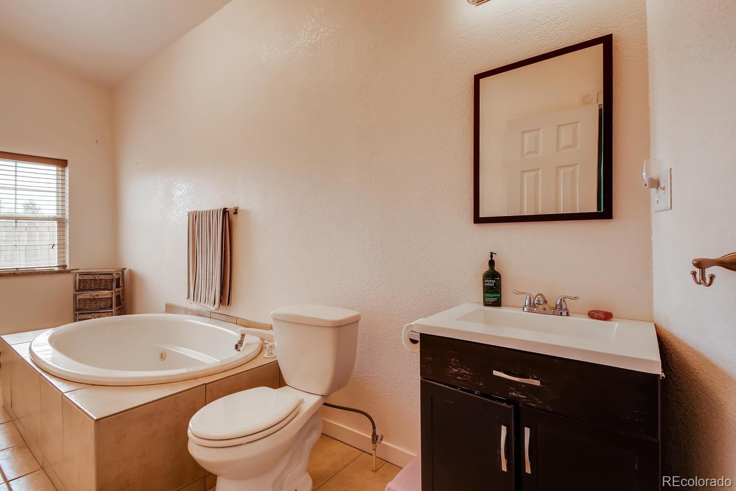 816 3rd Street Fort Lupton, CO 80621 - Photo 23 of 31 a bathroom with a toilet a sink and mirror