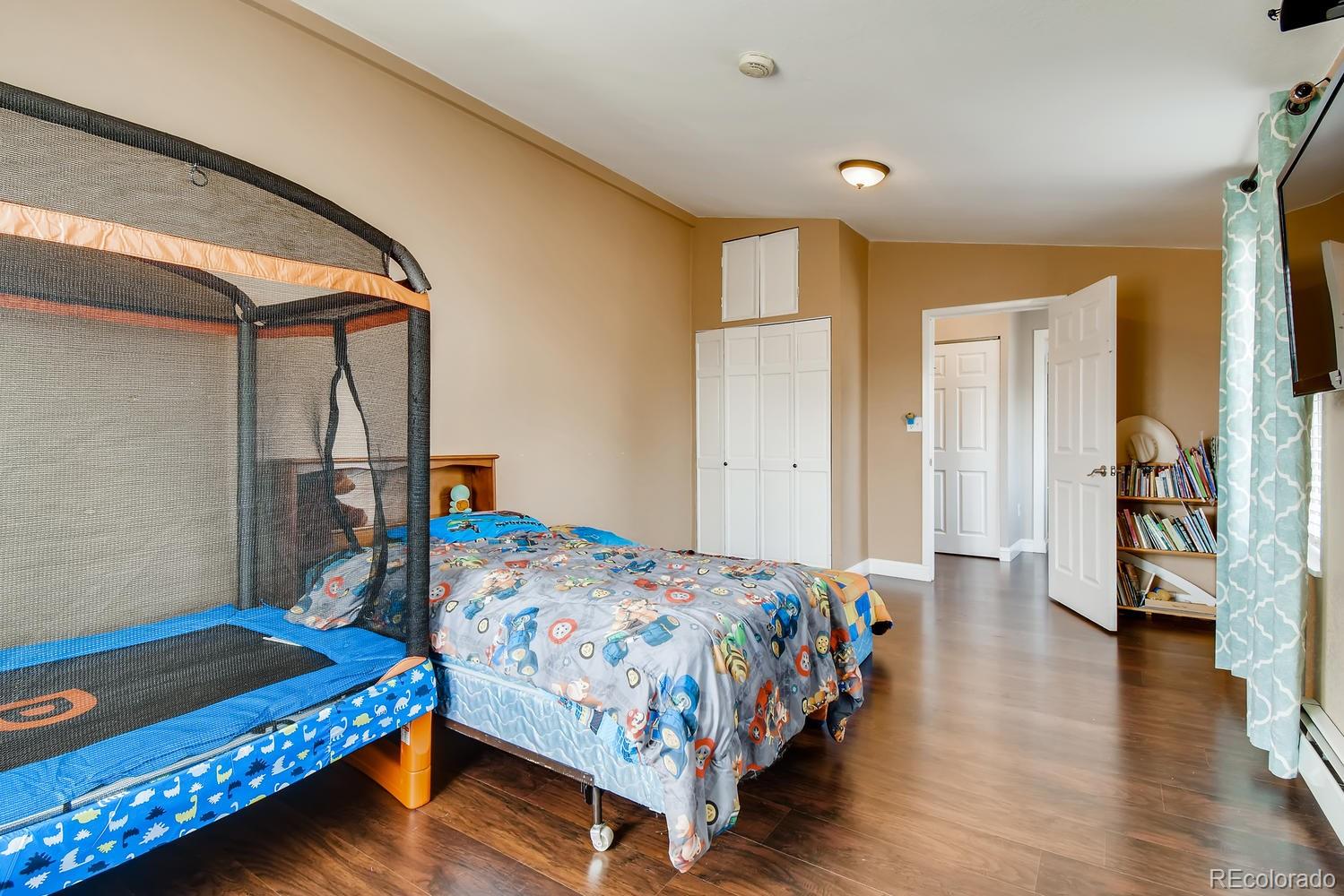 816 3rd Street Fort Lupton, CO 80621 - Photo 27 of 31 a bedroom with a bed and wooden floor