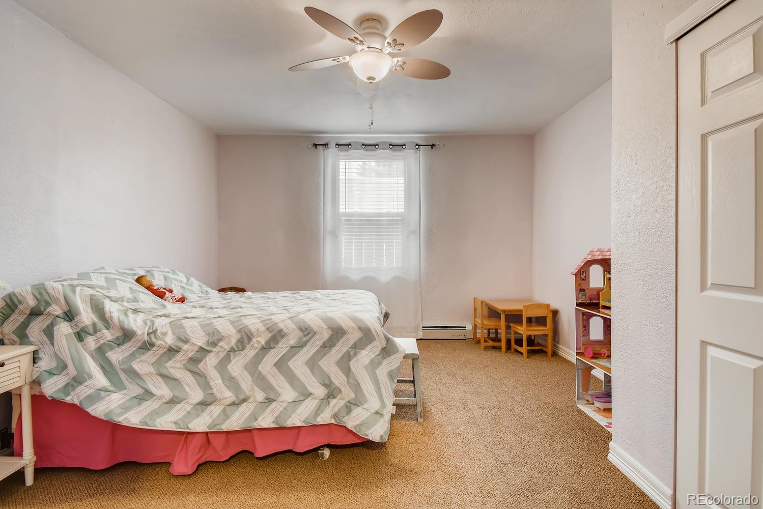 816 3rd Street Fort Lupton, CO 80621 - Photo 28 of 31 a bedroom with a bed and a chandelier