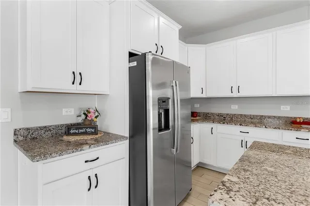 a kitchen with stainless steel appliances granite countertop a refrigerator a stove and a sink