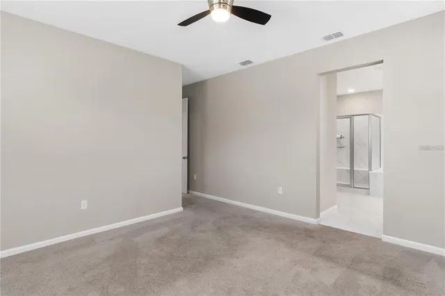 an empty room with chandelier fan