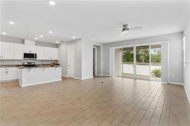 a view of kitchen with granite countertop stainless steel appliances refrigerator sink and cabinets