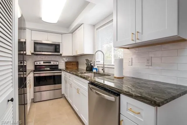 a kitchen with granite countertop a sink and steel appliances