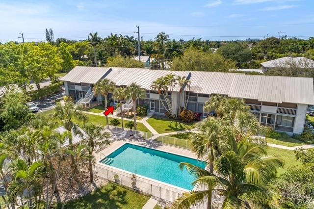 1251 7th Avenue North, Unit 307 Naples, FL 34102 - Photo 16 of 23 a view of a swimming pool with a patio and a garden