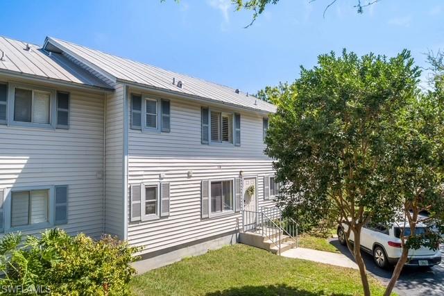 1251 7th Avenue North, Unit 307 Naples, FL 34102 - Photo 19 of 23 a front view of a house with garden