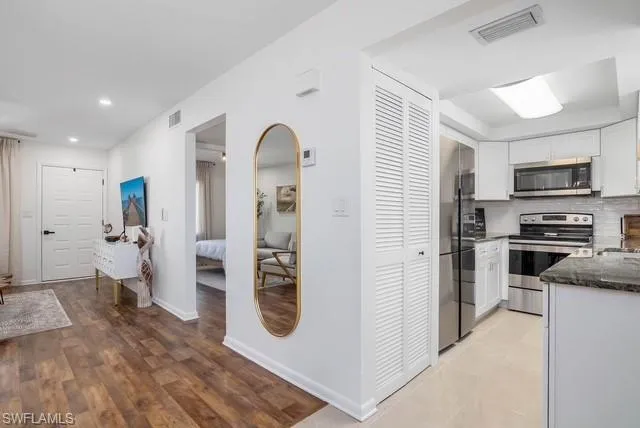 a kitchen with stainless steel appliances kitchen island granite countertop a refrigerator and a stove top oven