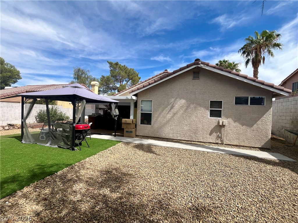 15 Rue Des Champs Henderson, NV 89074 - Photo 22 of 23 Low-maintenance gravel landscaping and a paved walkway define this back exterior space.
