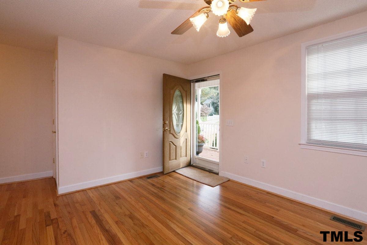 711 Edmund Street Raleigh, NC 27604 - Photo 3 of 25 a view of an empty room with wooden floor and a window