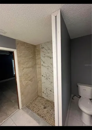 a bathroom with a toilet and a shower