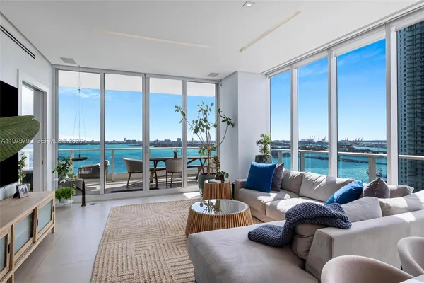 a living room with furniture large windows and a flat screen tv