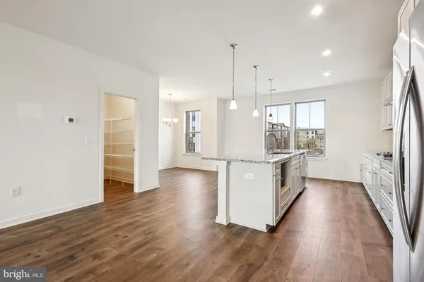 a large white kitchen with wooden floor and a sink