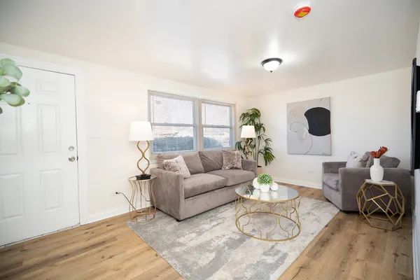 a living room with furniture a large window and a table