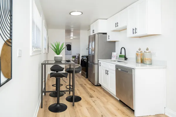 a kitchen with stainless steel appliances kitchen island granite countertop a sink a stove and refrigerator