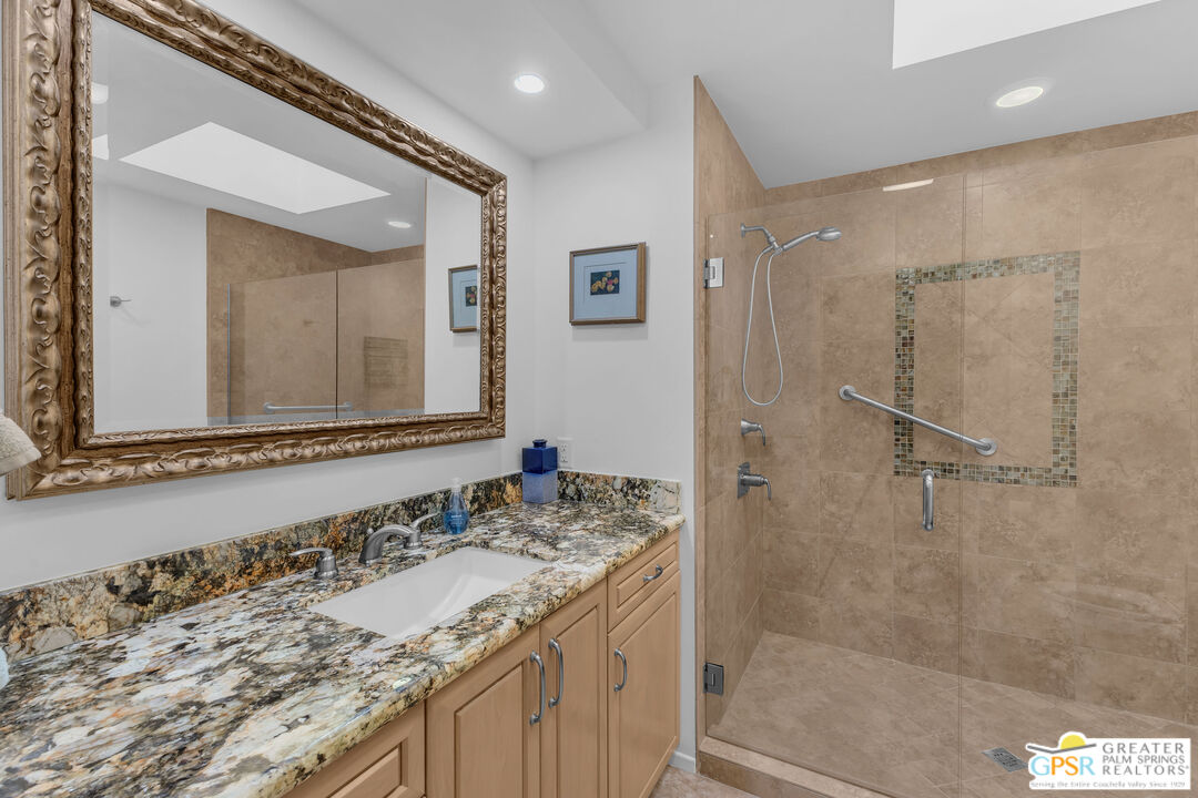 10 Colgate Drive Rancho Mirage, CA 92270 - Photo 35 of 45 a bathroom with a granite countertop sink a mirror and a shower