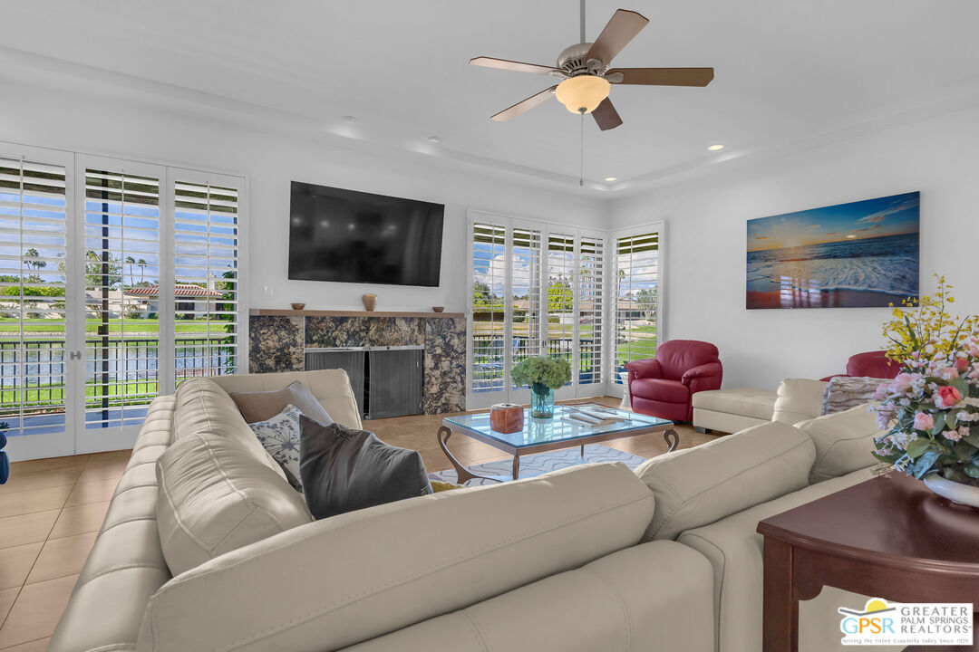 10 Colgate Drive Rancho Mirage, CA 92270 - Photo 6 of 45 a living room with furniture a flat screen tv and a floor to ceiling window
