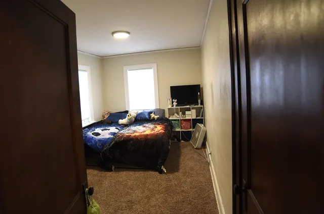 a bedroom with a bed and a flat tv screen on the table