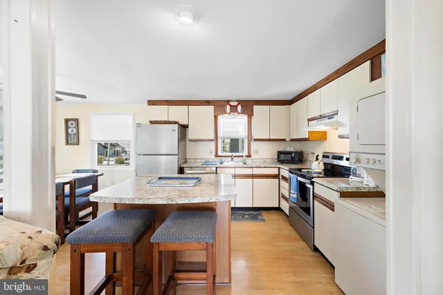 a living room with stainless steel appliances kitchen island granite countertop furniture and a kitchen view