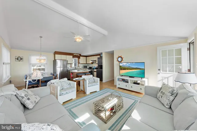 a living room with furniture flat screen tv and a large window