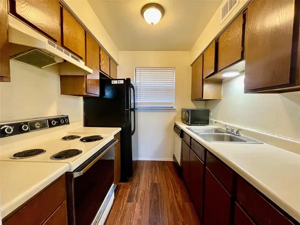 a kitchen with a sink a stove and a refrigerator