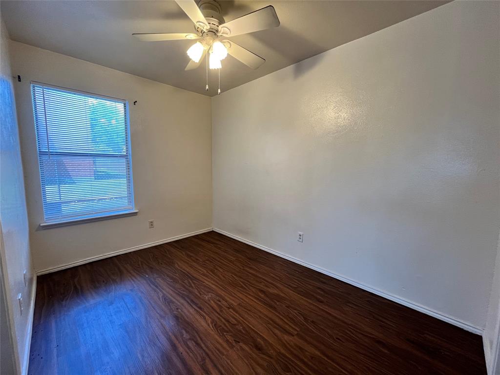 2526 West Prairie Street, Unit 203 Denton, TX 76201 - Photo 4 of 7 a view of an empty room with wooden floor and a window