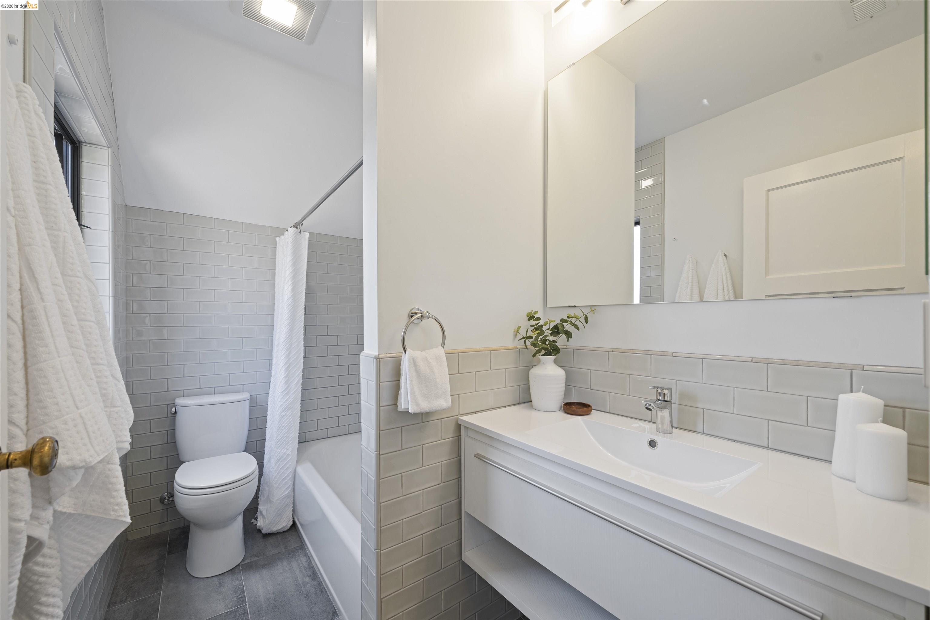 1170 Sterling Avenue Berkeley, CA 94708 - Photo 35 of 52 Bathroom featuring tile walls, vanity, a wainscoted wall, and shower / bath combination with curtain