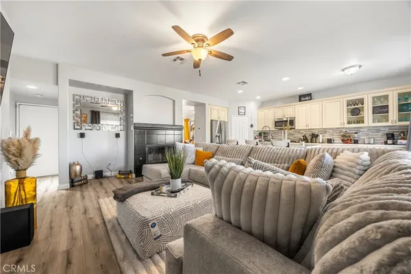 a living room with furniture kitchen view and a flat screen tv