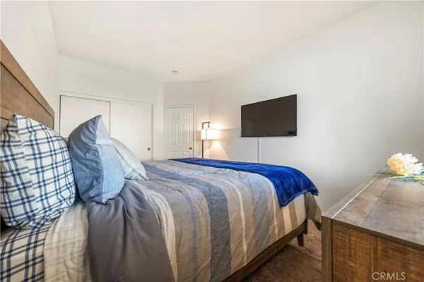 a bedroom with a bed and a flat screen tv