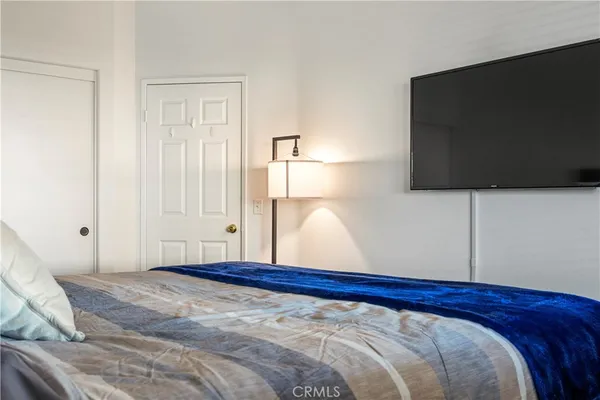 a bedroom with a bed and a flat screen tv