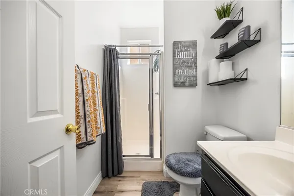a bathroom with a granite countertop sink a toilet and a shower