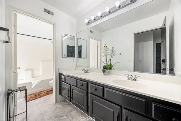 a spacious bathroom with a double vanity sink mirror and bathtub