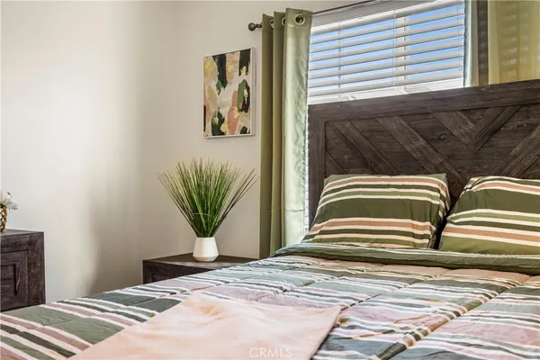 a bedroom with a bed and a potted plant