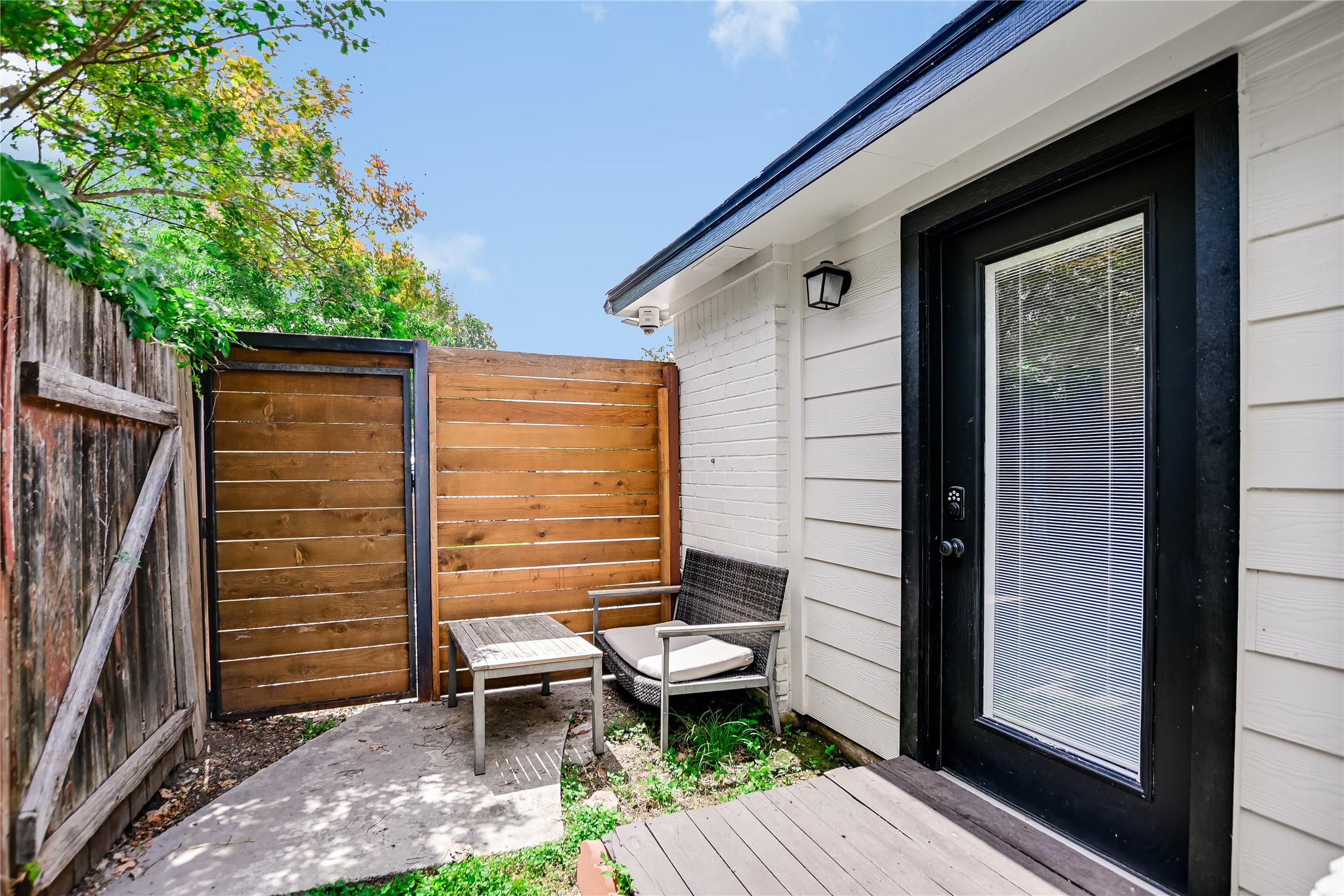 4702 Crest Oak Road Austin, TX 78744 - Photo 17 of 20 Private patio area featuring a modern wood slat fence with a metal gate