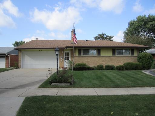 a front view of a house with a garden and plants
