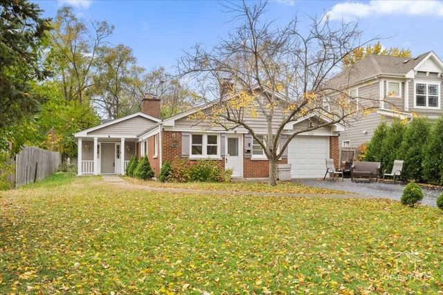 a front view of a house with a garden and trees